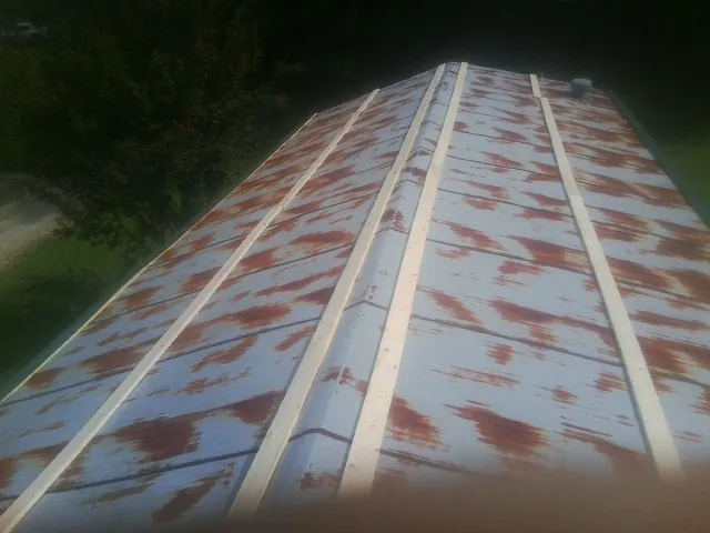 Rusted metal roof panels with new wood purlins before replacement — Storm Damage Roof Repair in Harriman by Roofing Brothers