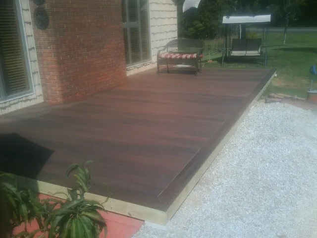 Freshly stained wood deck built against a brick home in Harriman