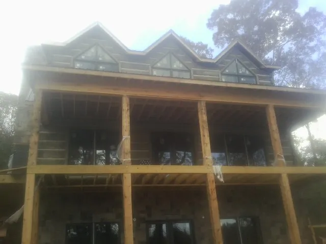 Dormers and porch framing on a large log home under construction — Roof Coating work by our crew in Harriman